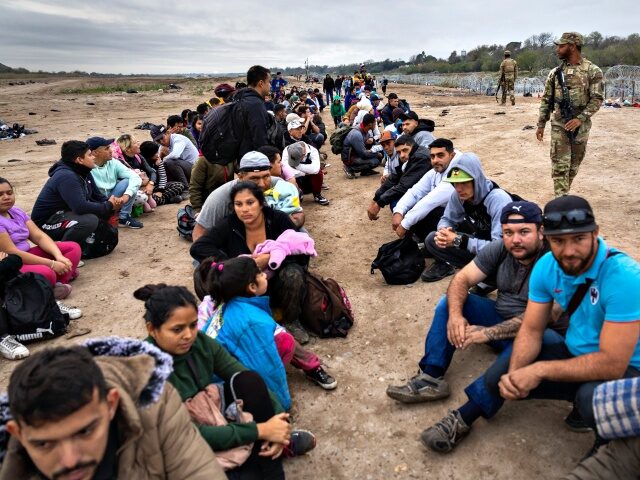 EAGLE PASS, TEXAS - DECEMBER 20: A Texas National Guard soldier counts a group of immigran