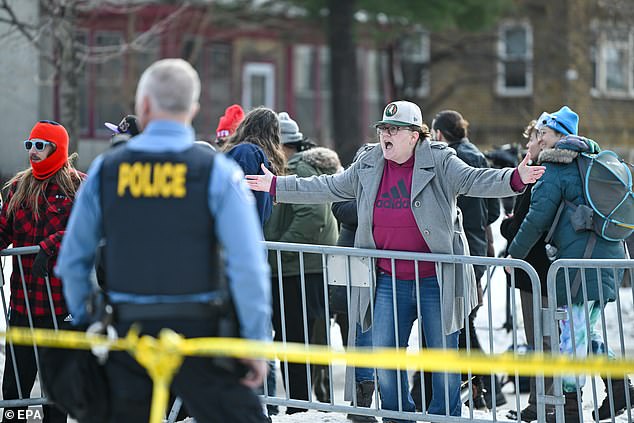 A person yells at Minneapolis police officers near the scene where Good was shot and killed