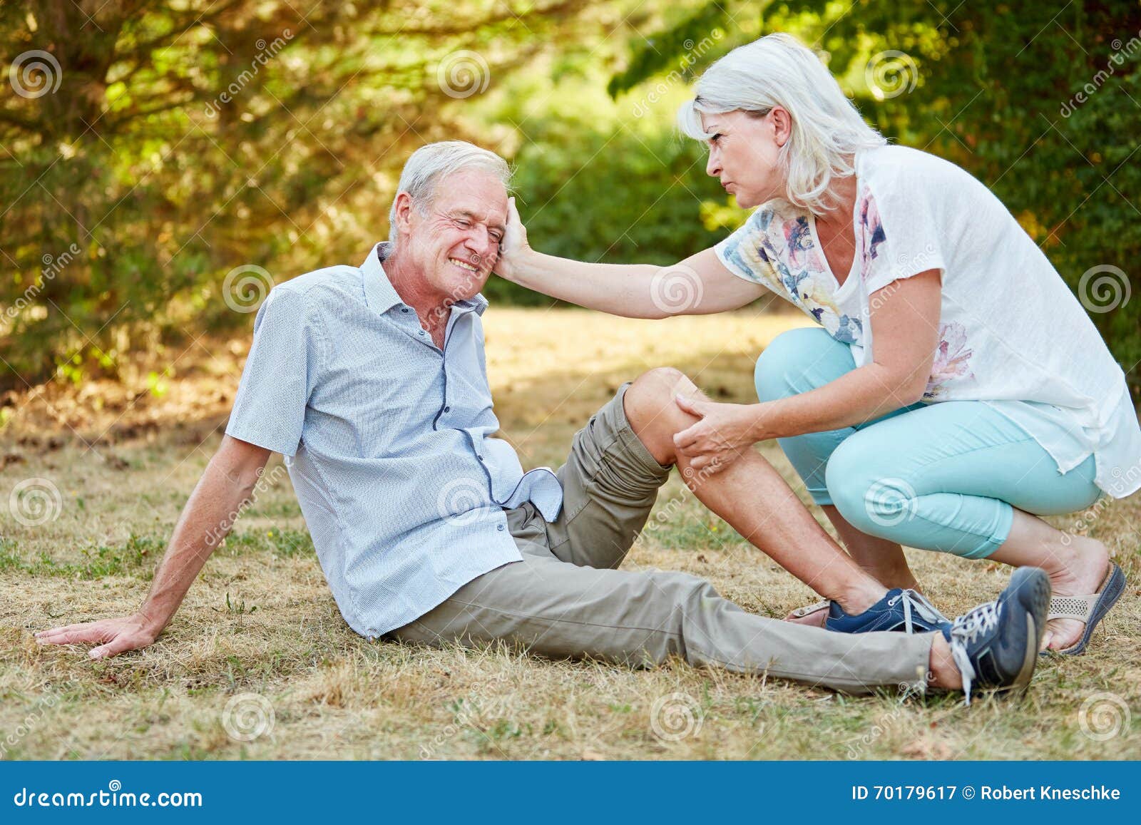 woman-gives-first-aid-to-man-comforts-him-men-knee-injury-70179617.jpg